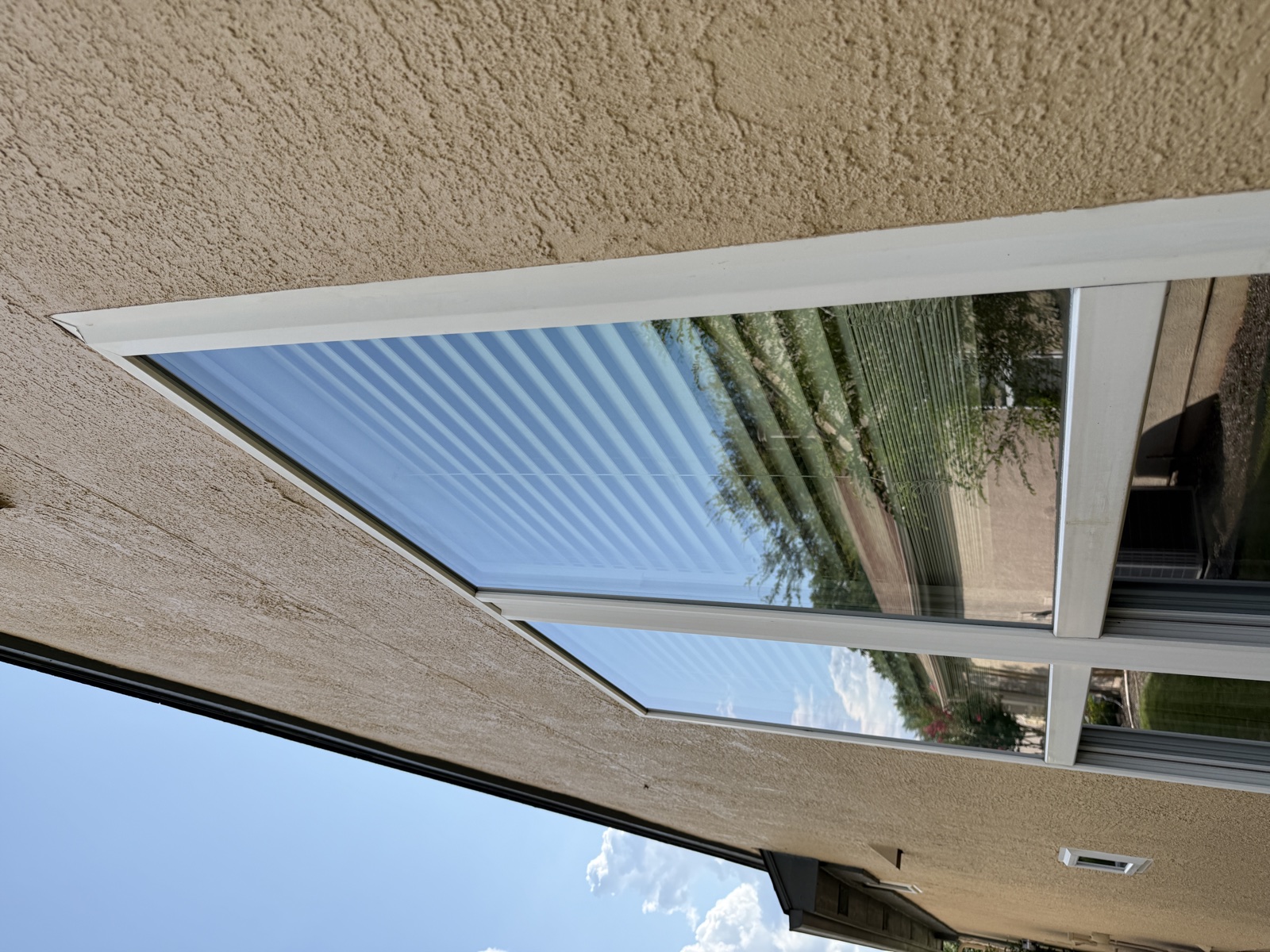 Residential side windows reflecting a clear blue sky after cleaning